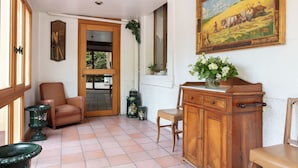 A room with a wooden cabinet, a chair, a table, and a painting on the wall. - Le Belvédère (Brides-les-Bains)