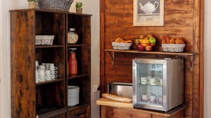 A kitchenette with a wooden cabinet, a bread loaf, a fruit bowl, and a refrigerator. - Le Belvédère (Brides-les-Bains)