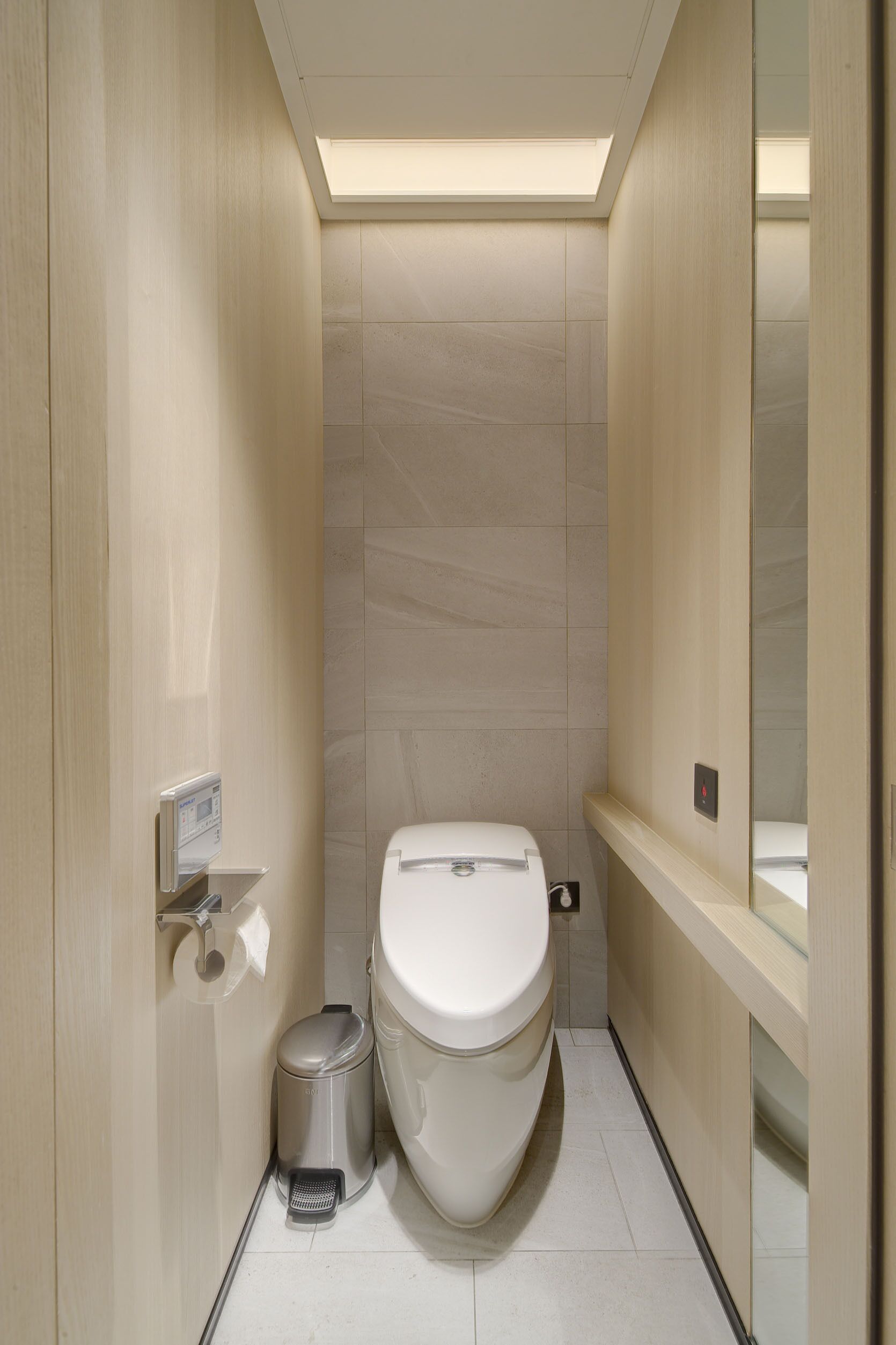Un bagno moderno con il water, un cestino e un asciugamani ad aria.
