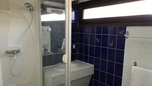 Une salle de bain avec une douche, un lavabo et des toilettes.