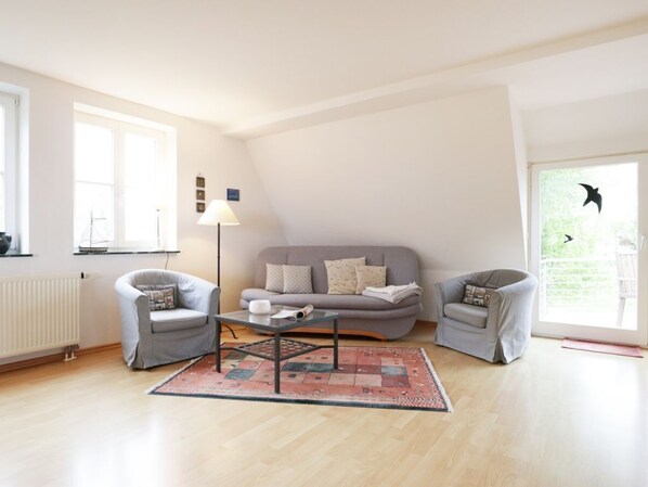 A modern living room with a grey sofa, two armchairs, a coffee table, and a floor lamp. - Beach view, Germany (Ostseebad Boltenhagen)