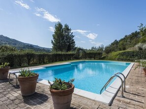 A rectangular swimming pool with a clear blue water surface, surrounded by a brick patio. - Poggio Ginepro Assisi with private pool, maximum privacy (Assisi)