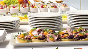 Un buffet proposant une variété de plats, notamment des fruits, des salades et des desserts.