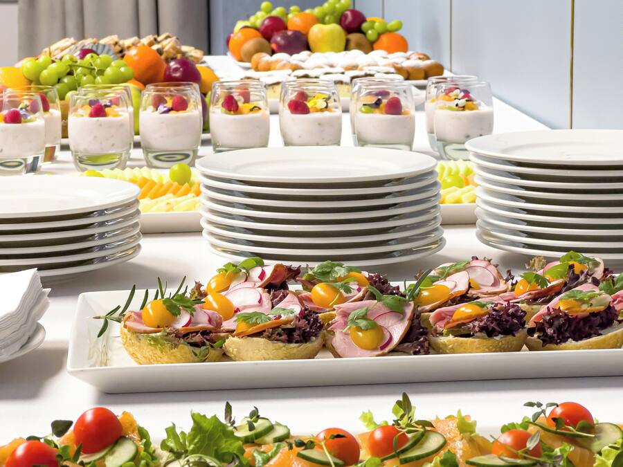 Un buffet proposant une variété de plats, notamment des fruits, des salades et des desserts.