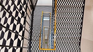 A staircase with a black and white checkered floor pattern. - Haston Old Town (Wroclaw)