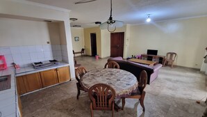 Un espacio habitable compacto con cocina, comedor y una pequeña zona de estar.