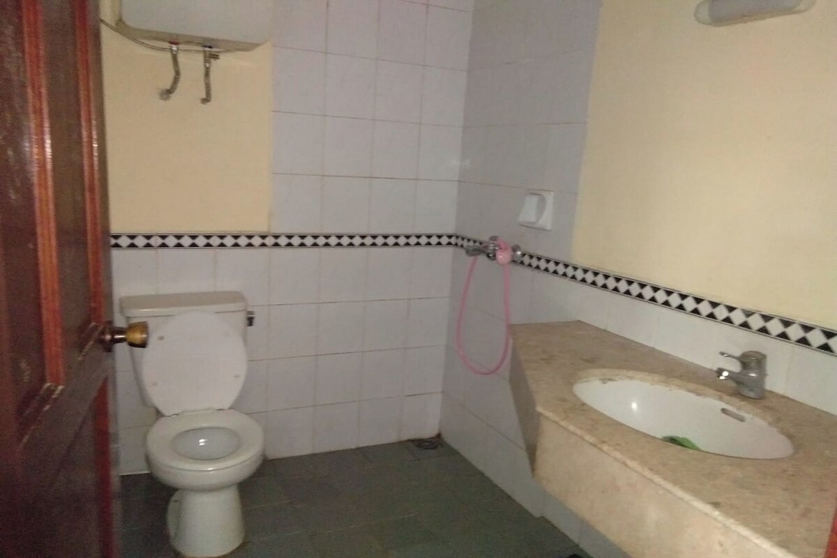 Um banheiro pequeno com vaso sanitário, pia e chuveiro.