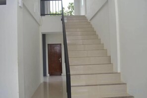 A staircase with a handrail, leading to a door at the top. - Alzara Hotel Syariah (Wonosari)