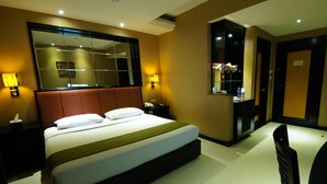 Une chambre d’hôtel avec un grand lit, des lampes de chevet, un miroir, un bureau et une chaise.