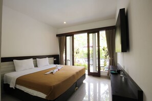 A hotel room with a bed, a flat-screen TV, and a view of the outdoors. - Dewivilla Hotel (Padangbai)