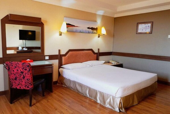 A hotel room with a bed, a desk with a chair, a television, and wall-mounted lamps. - Hotel Grand Crystal Kedah (Alor Setar)
