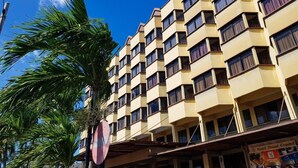A multi-story hotel with a symmetrical facade, balconies, and a clear sky. - Hotel Grand Crystal Kedah (Alor Setar)