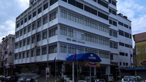 A multi-story hotel with a modern design, featuring a prominent entrance with a blue awning. - Hotel Anika (Kluang)