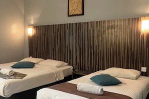 A hotel room with two beds, wooden headboard, and wall-mounted lights. - White Lodge (Langkawi)