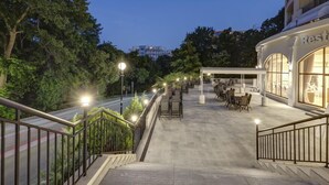 A rooftop terrace with outdoor seating, a covered area, and a building with a restaurant sign. - Hotel Continental (Golden Sands)