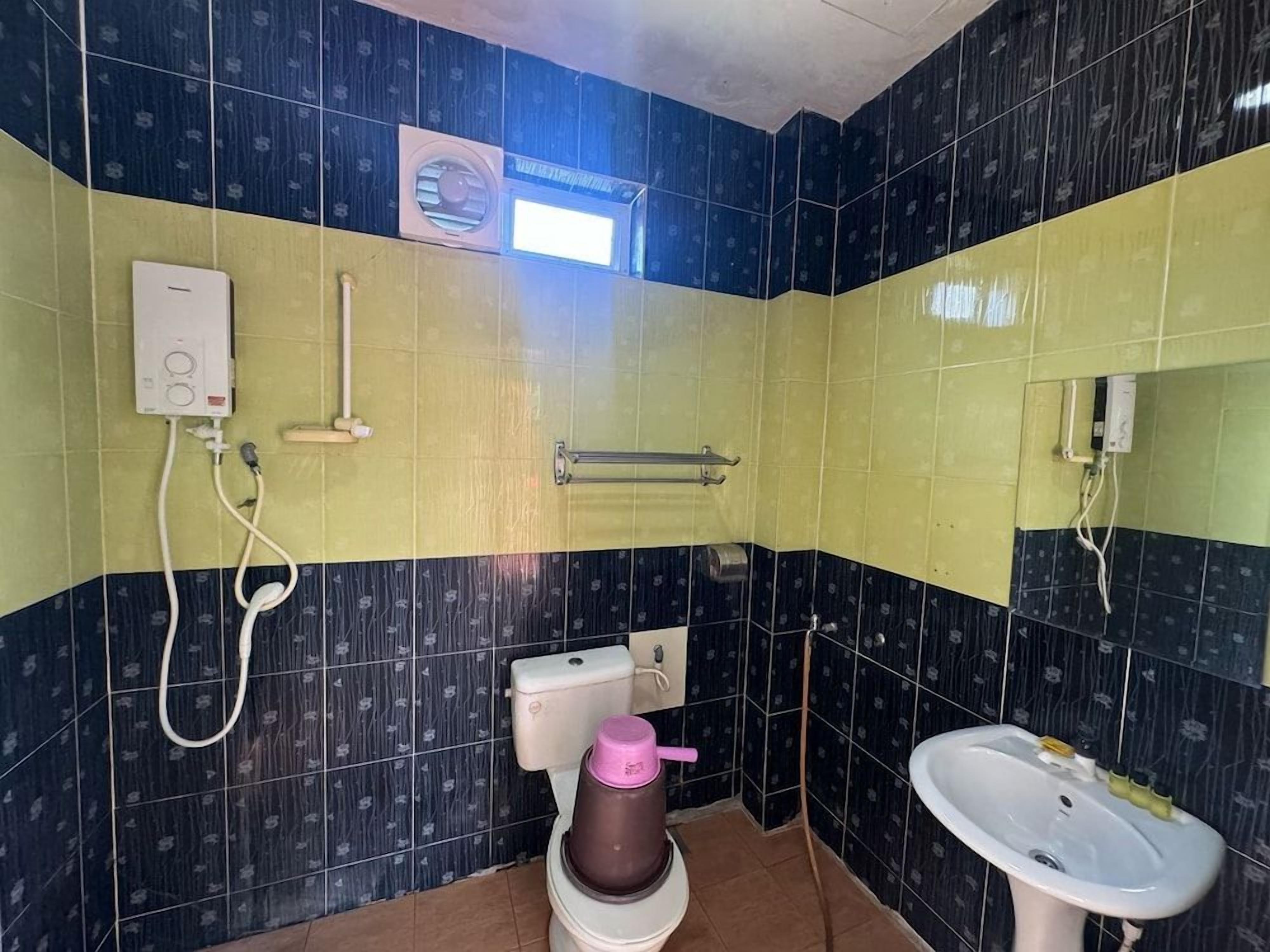 A bathroom with a toilet, bidet, sink, and a towel rack.