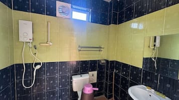 A bathroom with a toilet, bidet, sink, and a towel rack.