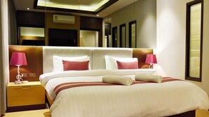 Ein modernes Hotelzimmer mit einem großen Bett, zwei Nachttischen und einem Spiegel über dem Bett.