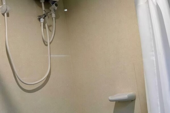 Une salle de bain avec une douche, des toilettes et une baignoire.