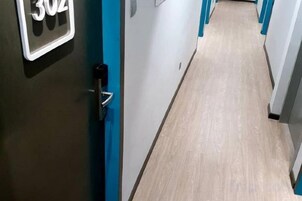 A hallway with doors, a door handle, and a light switch.