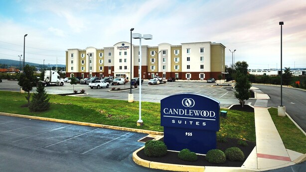 Un hotel con parcheggio, una segnaletica per Candlewood Suites e un edificio con diversi piani e finestre.