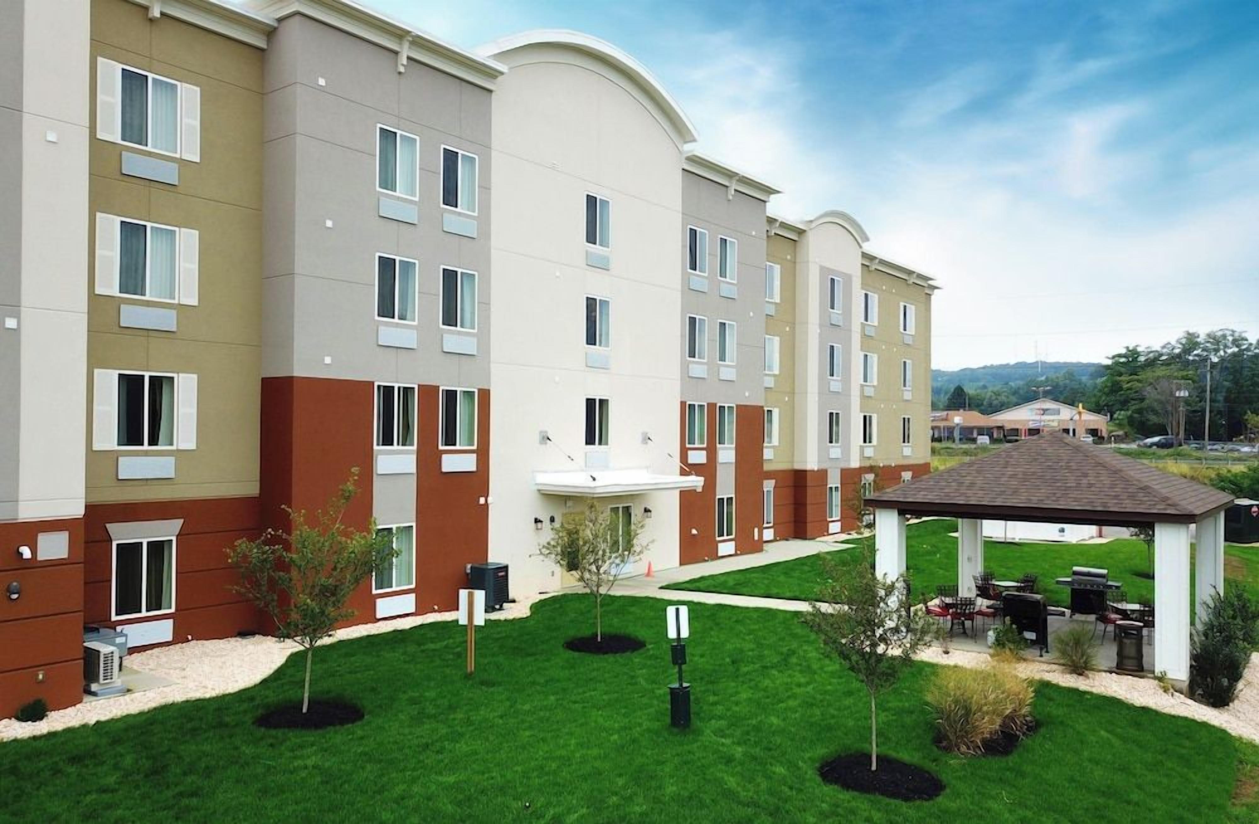 A multi-story hotel with a central courtyard, outdoor seating area, and a covered patio.