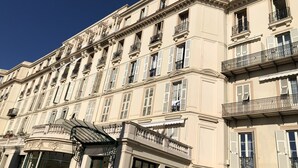 A multi-story building with classical architecture, featuring balconies with wrought iron railings and a central entrance with a canopy. - MENTON, VERY NICE STUDIO IN PALACE NEAR BEACHES AND STATION (Menton)