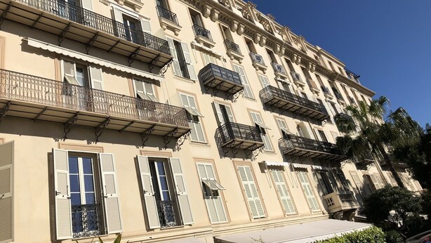A multi-story building with balconies, windows with shutters, and a clear blue sky. - MENTON, VERY NICE STUDIO IN PALACE NEAR BEACHES AND STATION (Menton)