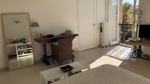 A bedroom with a bed, a desk, a chair, a wardrobe, and a large window. - MENTON, VERY NICE STUDIO IN PALACE NEAR BEACHES AND STATION (Menton)