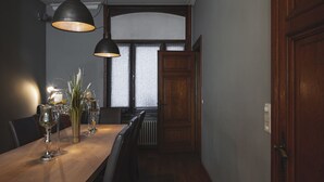 A dining area with a wooden table, chairs, and hanging pendant lights.