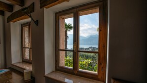 Una habitación con un amplio ventanal que da a un paisaje montañoso y una masa de agua.