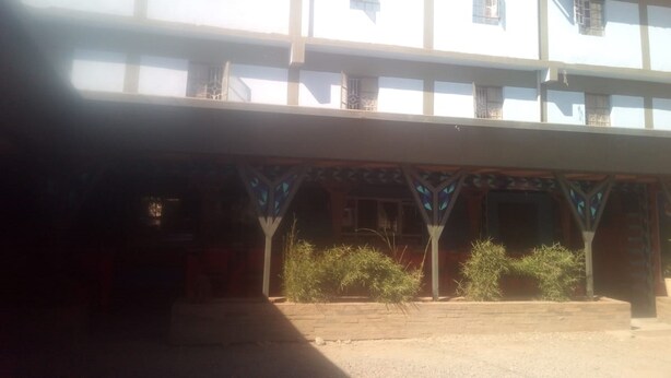 A multi-story building with a flat roof and a covered entrance area with decorative arches. - Jaws Palace Umoja (Nairobi)