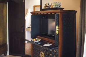 A compact kitchenette with a built-in refrigerator, a small countertop, and a bowl of fruit. - Saree Samui (Koh Samui)