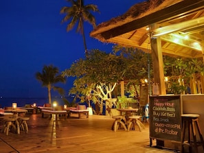 Relax in our ocean-view seating area with a thatched-roof structure and enjoy a refreshing drink at the pool bar.