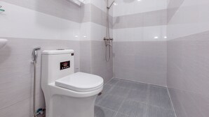 Un baño moderno con inodoro, ducha y toallero.