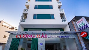 Un edificio de apartamentos de varios pisos con un cartel que dice 'CUONG HAI APARTMENT'.