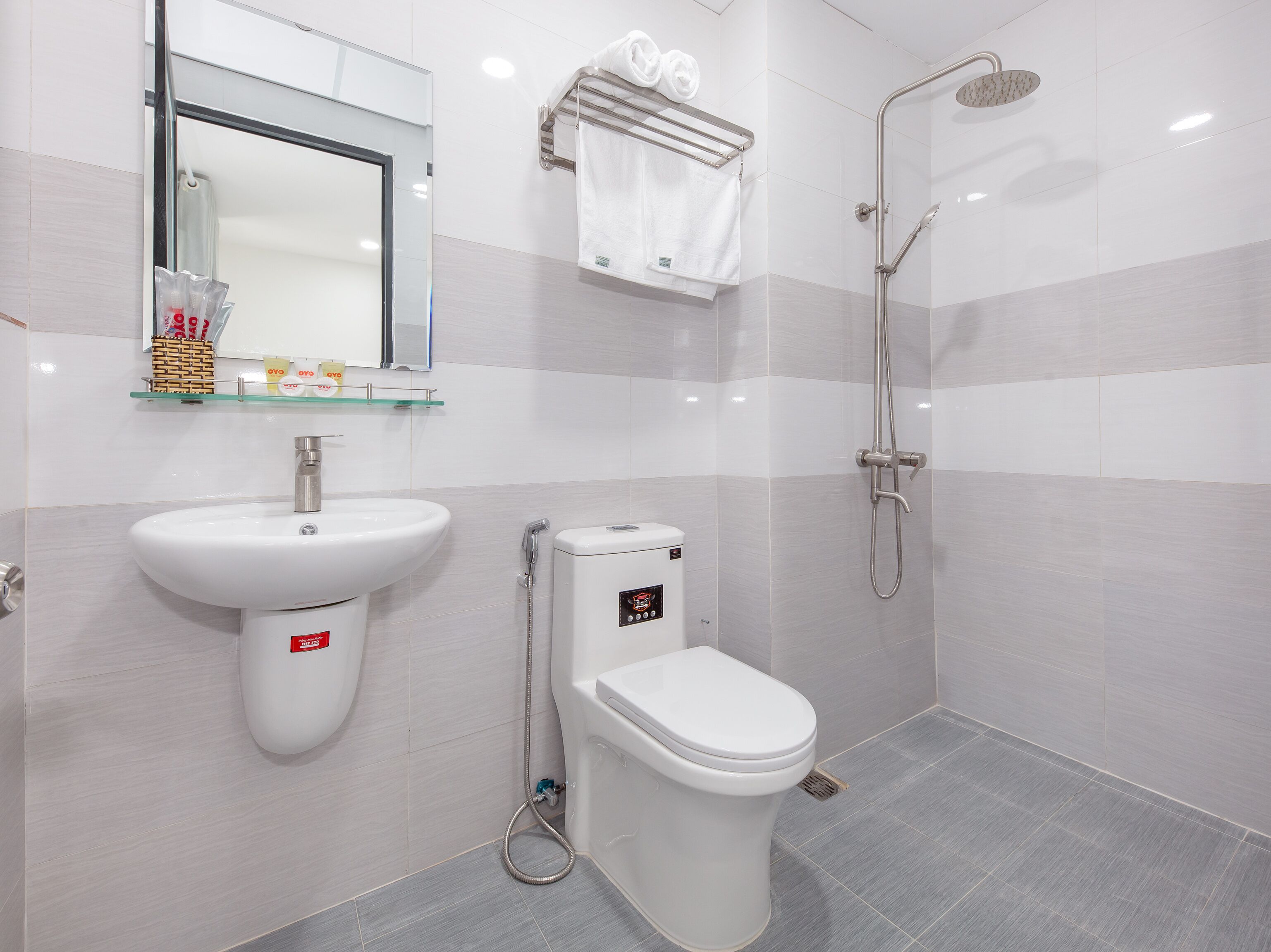 A modern bathroom with a sink, toilet, and shower.