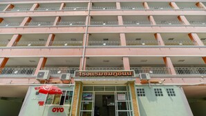 A multi-story building with a central entrance, balconies, and air conditioning units. - OYO 762 Chompoo (Nakhon Chai Si)