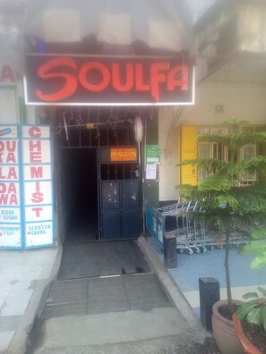 A storefront with a neon sign reading "SOULFA" and a sign prohibiting the sale of alcohol to persons under 18 years. - Soulfa Guest House (Nairobi)
