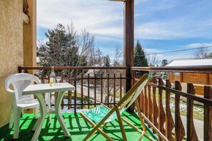 A balcony with a white plastic chair, a small table with a wine glass, and a hammock. - Homerez - Apartment in Bolquère, mountain view (Bolquère)