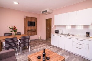 Apartamento, 1 habitación | Zona de estar | Televisión de pantalla plana de 74 cm con canales por satélite