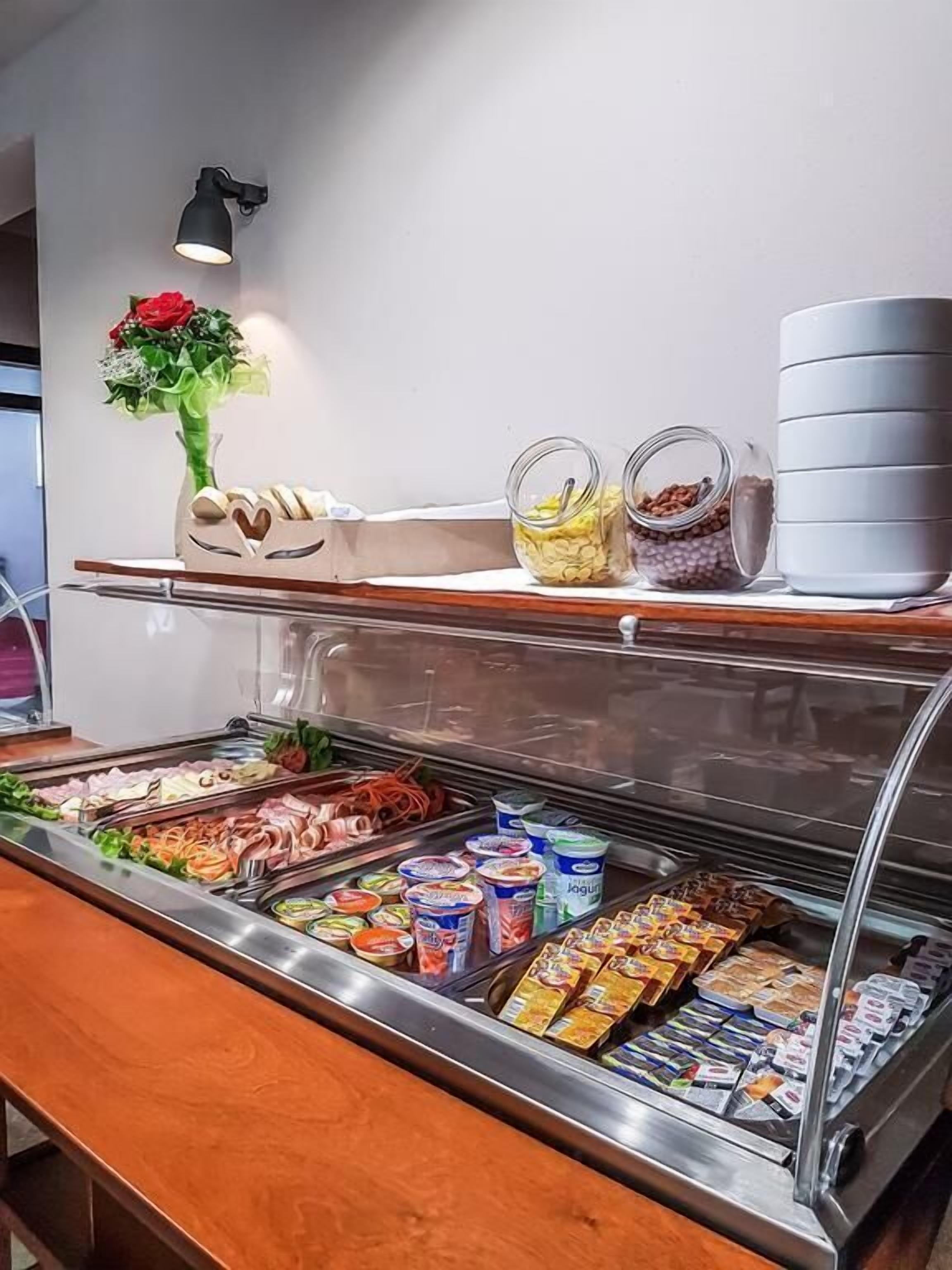Zona de bufé con diferentes opciones de comida, como frutas, yogures y aperitivos envasados.