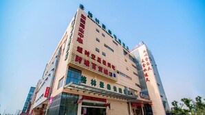 A multi-story hotel with a prominent entrance, large windows, and a clear sky.