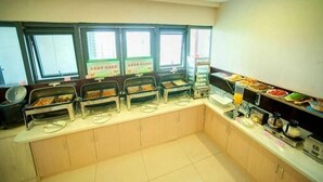 A buffet setup with multiple food stations and a juice dispenser.