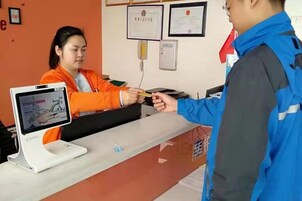 Una recepción con un mostrador, pantalla digital y una pared con certificados.