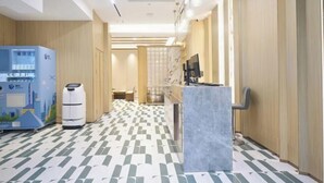 A hotel lobby with a check-in counter, a vending machine, and a seating area. - Crystal Haolaideng Hotel (Dehua)