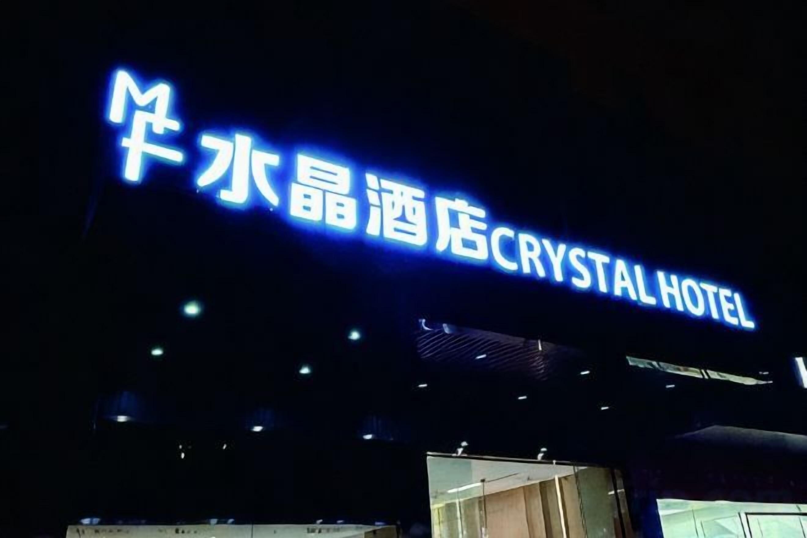Un cartell d'hotel amb caràcters xinesos i el nom 'Crystal Hotel' en anglès.