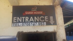 A sign for Jambo Guest House indicating the entrance direction and a telephone number. - Jambo Guest House (Nairobi)