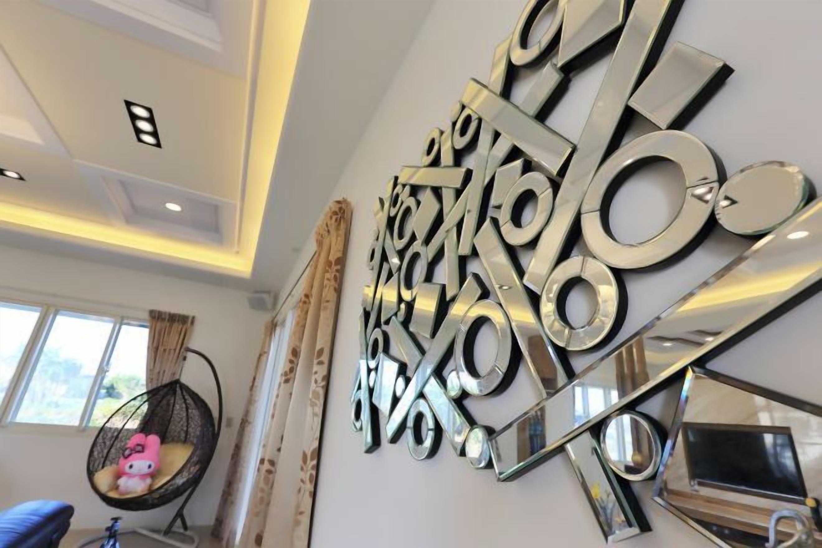 A modern interior with a wall-mounted abstract metal art piece, a hanging chair, and a bicycle.
