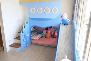A children's bedroom with a bed, a pig-themed headboard, and a window. - relax bnb (Yilan)